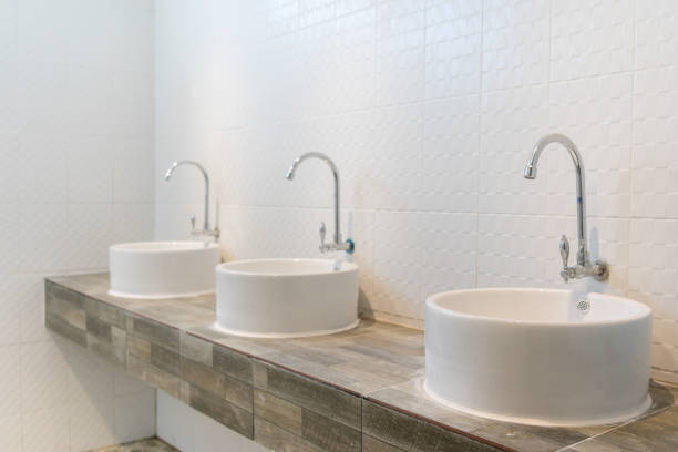 istock Three sinks on wood pattern tiles counter in bathroom 1545311847
