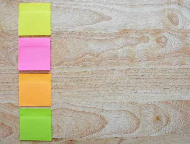 istock Blank colorful sticky notes on wooden surface. 1545344192