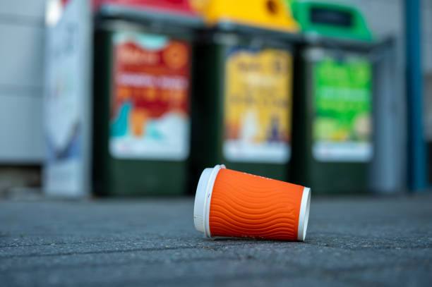 istock coffee cup with a red straw is thrown into the green grass. Environmental pollution with household waste. 1545371511