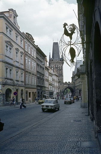 Czechoslovakia, Czech Republic, Prague, 1981. Street scene in the old town of Prague with the Lesser Town Tower in the background. Also: pedestrians, buildings and cars.