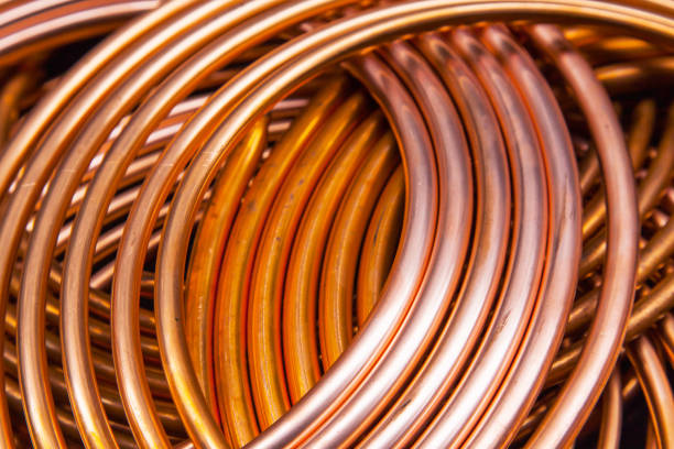 istock Twisted new copper tubes on a black background. 1545396050