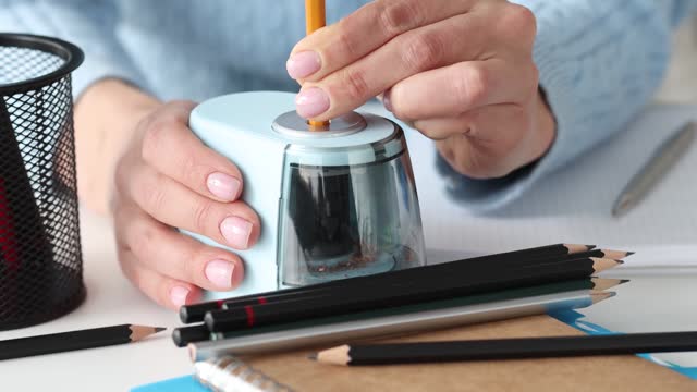 Woman sharpening pencils with electric sharpener in studio 4k movie