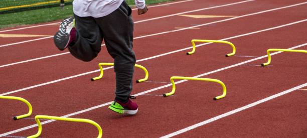istock African American runner running over yellow mini hurdles on a track 1545457954