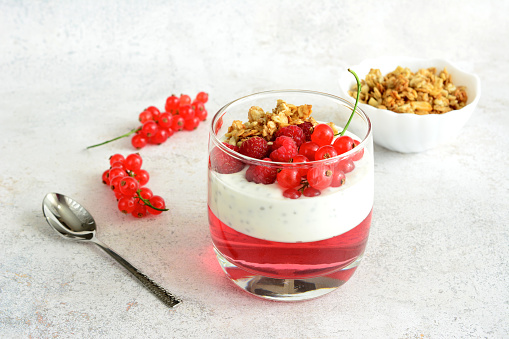 chia pudding with raspberry, red currant and jelly in drinking glass