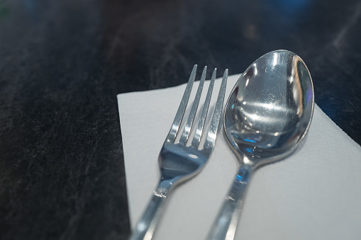Closeup stainless steel spoon and fork on dinning table
