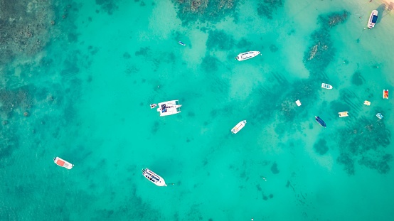 An aerial view of boats moored in the crystal clear turquoise sea. Mauritius, East Africa.