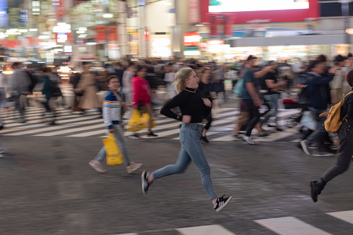Tokyo, Japan - October 30, 2019: Shibuya Crossing in Tokyo, Japan. The most famous intersection in the world. Blurry because of the panning.