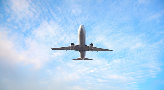 White passenger airplane flying in the sky amazing clouds in the background - Travel by air transport