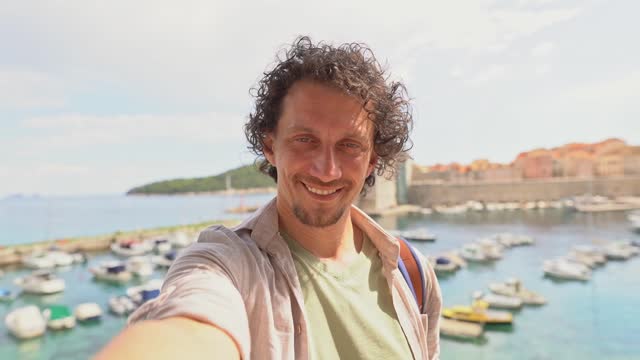 Man with curly hair by the city port