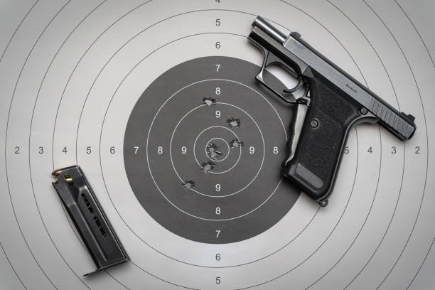 istock Gun, ammo magazine and paper target with holes 1545632904