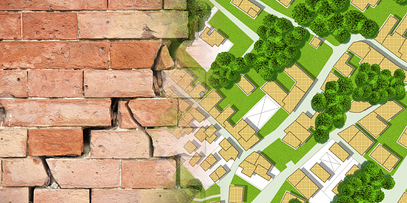 Areas of the city with subsidence phenomena that damage buildings - concept with an imaginary city map and cracked brick wall