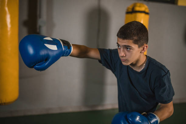 istock Strong young kickboxer is training in a boxing gym and preparing for a boxing match and boxing competition 1545667382