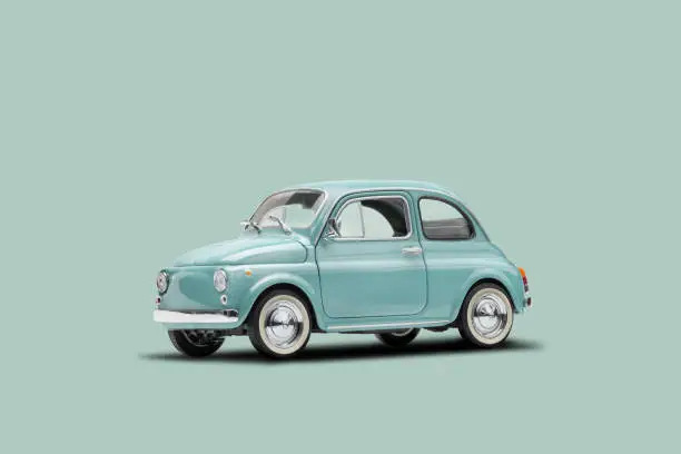 Photo of Miniature retro toy car on a pastel blue background with copy space