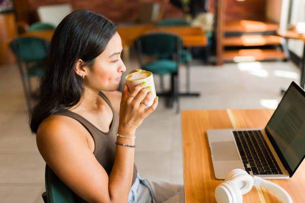 istock Attractive woman doing freelance work in the coffee shop 1545688318