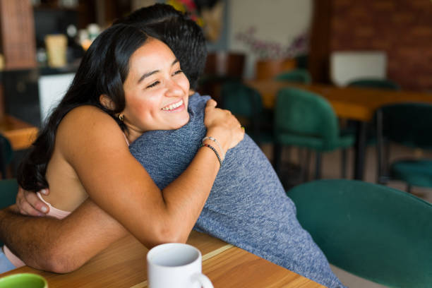 istock Romantic couple hugging and smiling while at the cafe 1545710027
