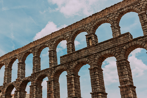 View of the ancient Roman aqueduct against the blue sky.