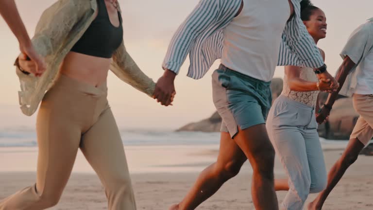 Holding hands, happy or friends running at beach at sunset on holiday vacation bonding or walking together. Smile, freedom or funny group of people relaxing on sand on ocean trip in Miami or nature