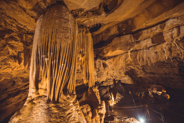 istock Big underground hall in a cave filled with stalactites and stalagmites forming pillars and other rock formations. Taborska or Zupanova cave in Slovenia 1545755214
