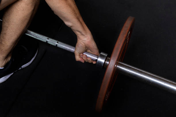 Unrecognizable Latin American man performing functional workouts executed at high intensity in the gym using a barbell with weights. Healthy Lifestyle Concept