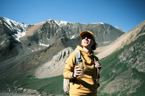 istock Female backpacker is drinking water on mountain pass 1545756114
