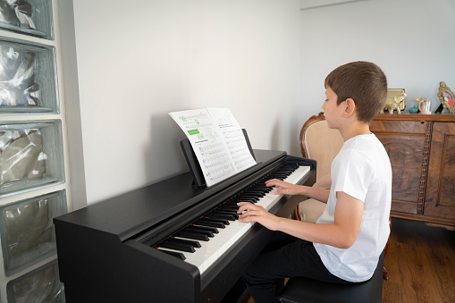 Little boy having fun practicing piano.