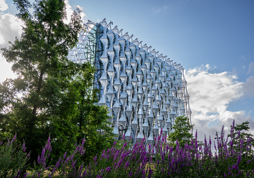 Nine Elms, London, UK: The Embassy of the United States of America in London with purple flowers in the foreground. The US Embassy is located in the redeveloped area of Nine Elms.