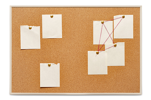 Blank paper notes are pinned to a cork board. The concept of detective investigation. Copy space