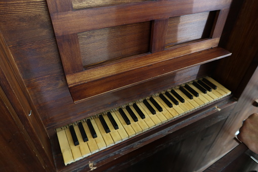 Old black grand piano keyboard with keys from ivory and ebony, part of a musical instrument in panoramic format, copy space, selected focus, narrow depth of field