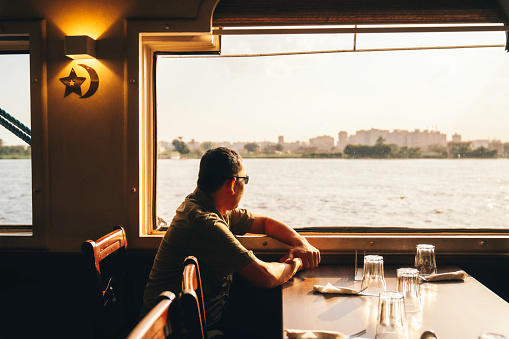 portrait of happy man who travels on a boat during sunset on nile river, Cairo