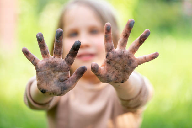 Little girl showing her dirty hands stock photo