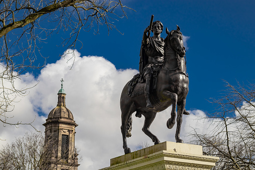 Statue of william the third in centre of Glasgow, scotland on a sunny day. Person on a horse pointing towards the camera.