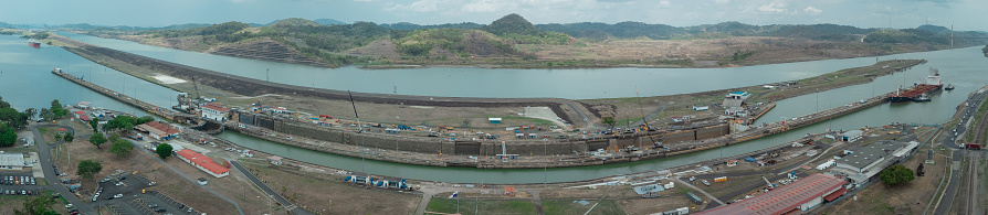 Pedro Miguel locks in Panama, famous channel shortcut in central America. Visible ships and channels with locks. Drone view on a cloudy but sunny day in spring.