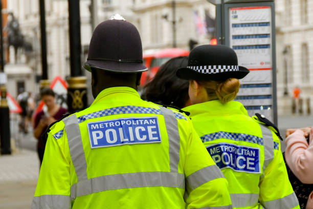 Rear view of police officers of the Metropolitan Police Force London, England, UK - 27 June 2023: Two police officers of the Metropolitan Police on patrol in central London. metropolitan police stock pictures, royalty-free photos & images