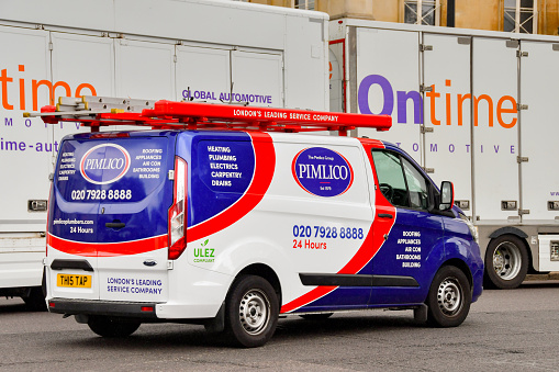 London, England, UK - 27 June 2023: Van operated by the Pimlico plumbing and service company driving on a road in central London