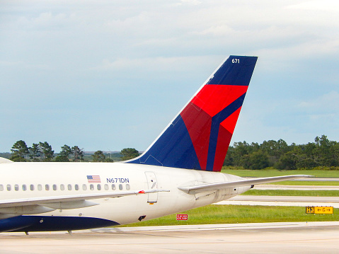Orlando, Florida, USA - 24 June 2023: Tail fin of a Delta Air Lines Boeing 757 passenger jet at Orlando airport.