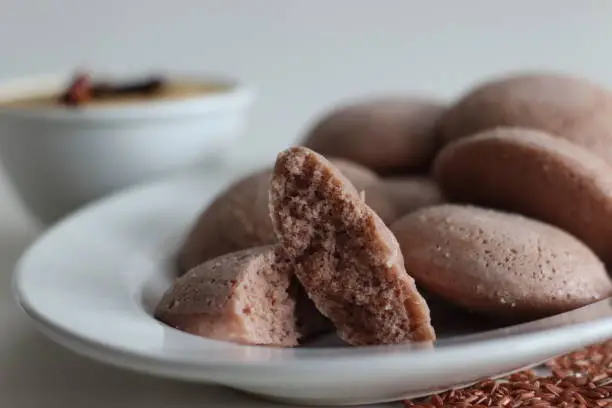 Navara rice idly. Steamed savoury rice cake made by a batter of fermented de husked black lentils and navara rice. Navara rice is an endemic rice with many medicinal value and has a unique red colour