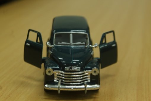 A miniature of an old metal car with an open door