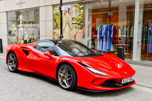 London, England, UK - 27 June 2023: Ferrari F8 Spyder supercar parked on a street outside designer shops in central London,.