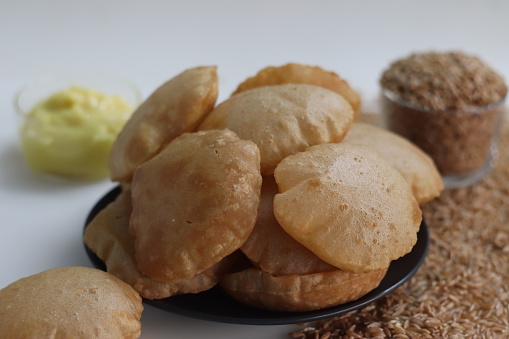 Khapli wheat puris. Deep fried Indian flatbread made of emmer wheat flour served with shrikhand, sweetened yogurt popular in India. A version of puri with oldest wheat varieties of India