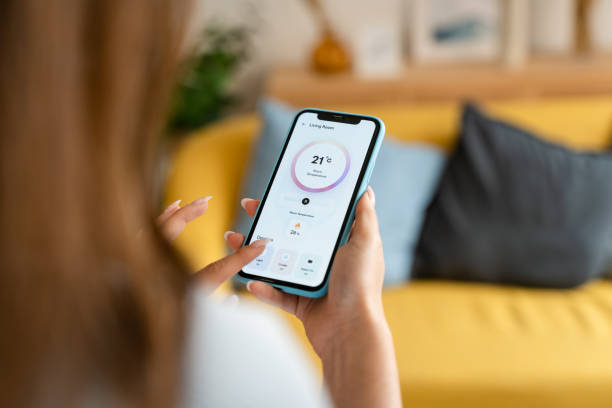 istock Woman controlling the temperature with a mobile phone. 1545831043