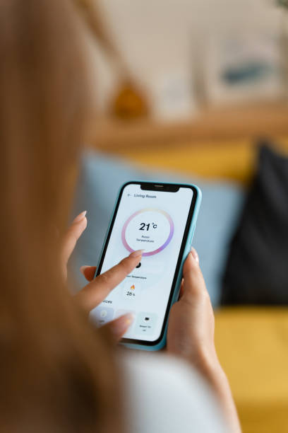 istock Woman controlling the temperature with a mobile phone. 1545832142