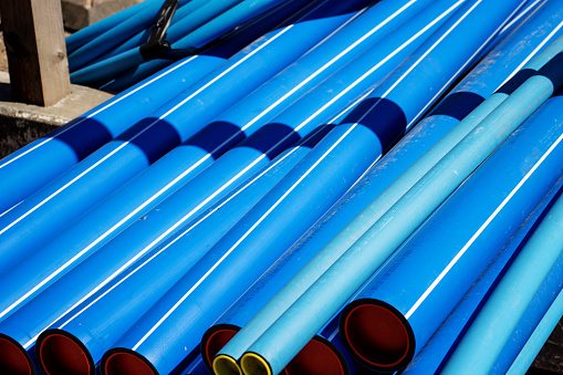 blue plastic pipe conduit laying in a pile ready for use in in Copenhagen, Denmark