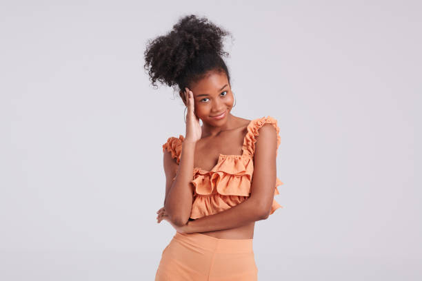 istock Stunning Style: Black Girl in Orange Shirt Strikes a Pose 1545872992