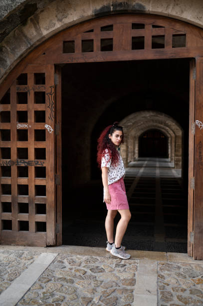 istock Woman posing next to ancient door with a tunnel 1546026056
