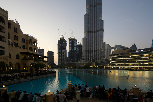 Dubai, UAE - August 28, 2022: Mall square and lots of people walking and waiting for fountains show.