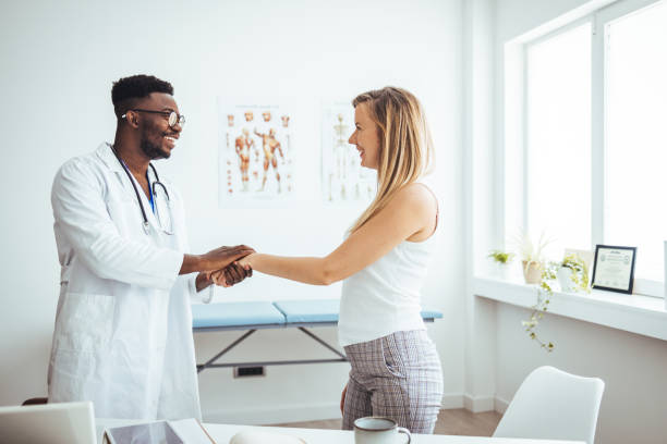 istock Doctor shaking hands with woman. 1546163179