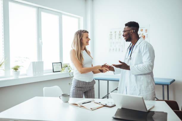 Doctor shaking hands with woman.