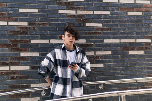 istock young man with a phone against a brick wall 1546205800