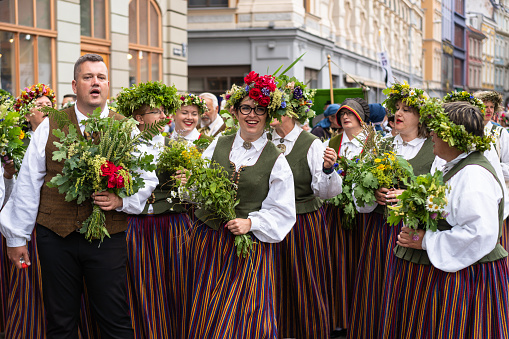 Riga, Latvia - June 2, 2023: Parade participants in folk costumes on the streets of the Old Town before the march