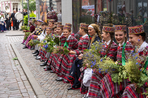 Riga, Latvia - June 2, 2023: Parade participants in folk costumes on the streets of the Old Town before the march